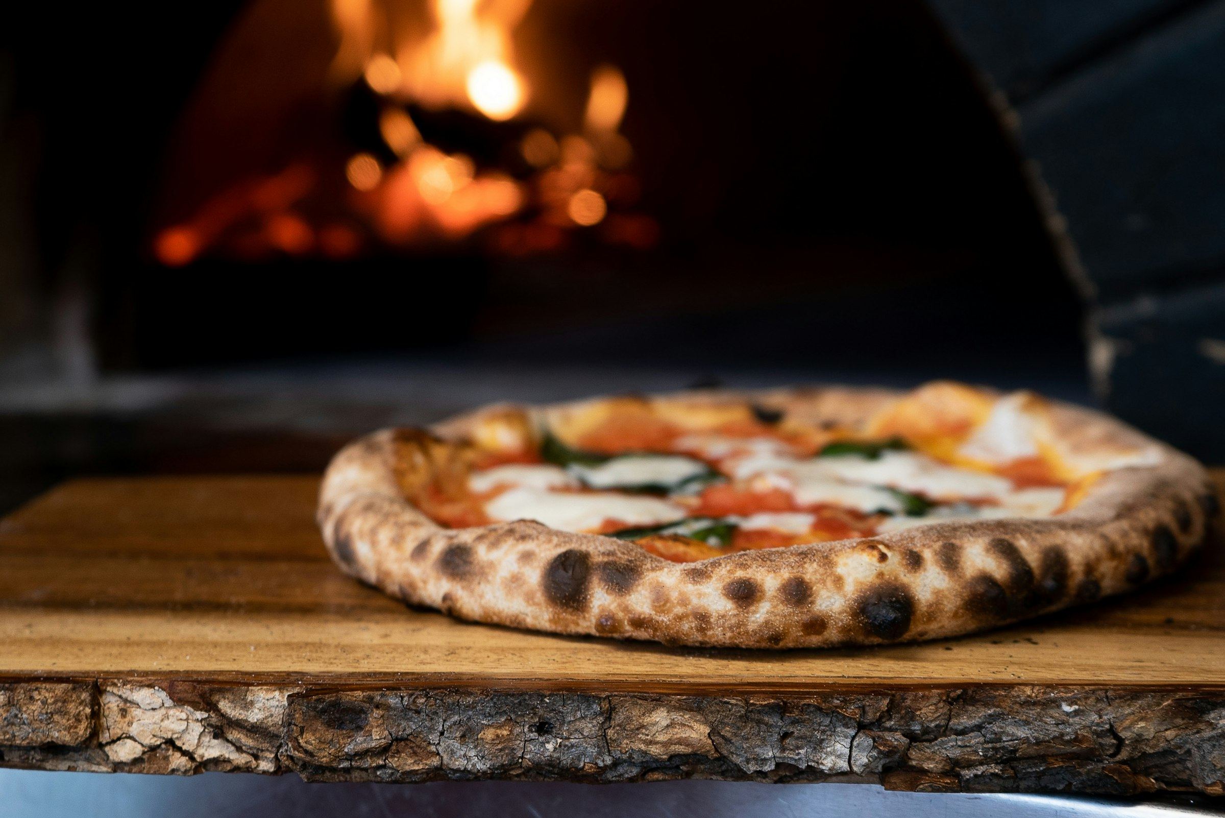Wood-fired pizza fresh from the oven (stock photo placeholder)